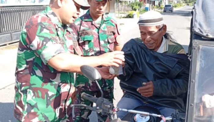 Satgas TMMD dan Babinsa Koramil 16/DMS Bagikan Nasi Bungkus Kepada Warga