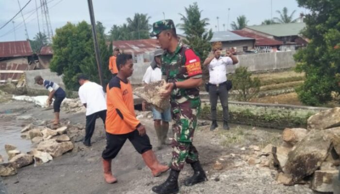 Babinsa Koramil 16/DMS Gotong Royong Perbaiki Jalan Tergenang Bersama Warga